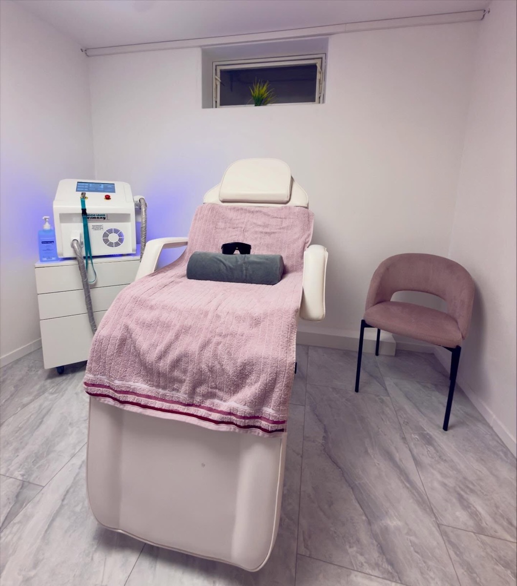 Behandlungsraum mit Liege, Diodenlaser und rosa Sessel